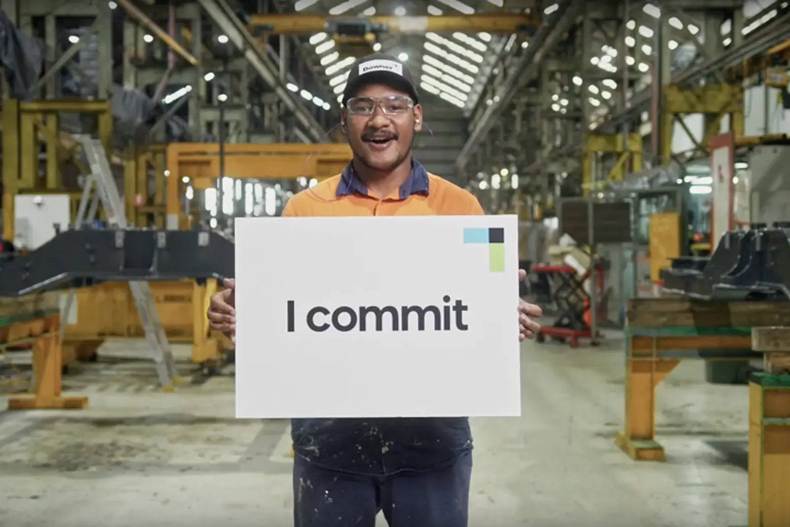 Downer rail worker holding an I commit sign at a safety workshop